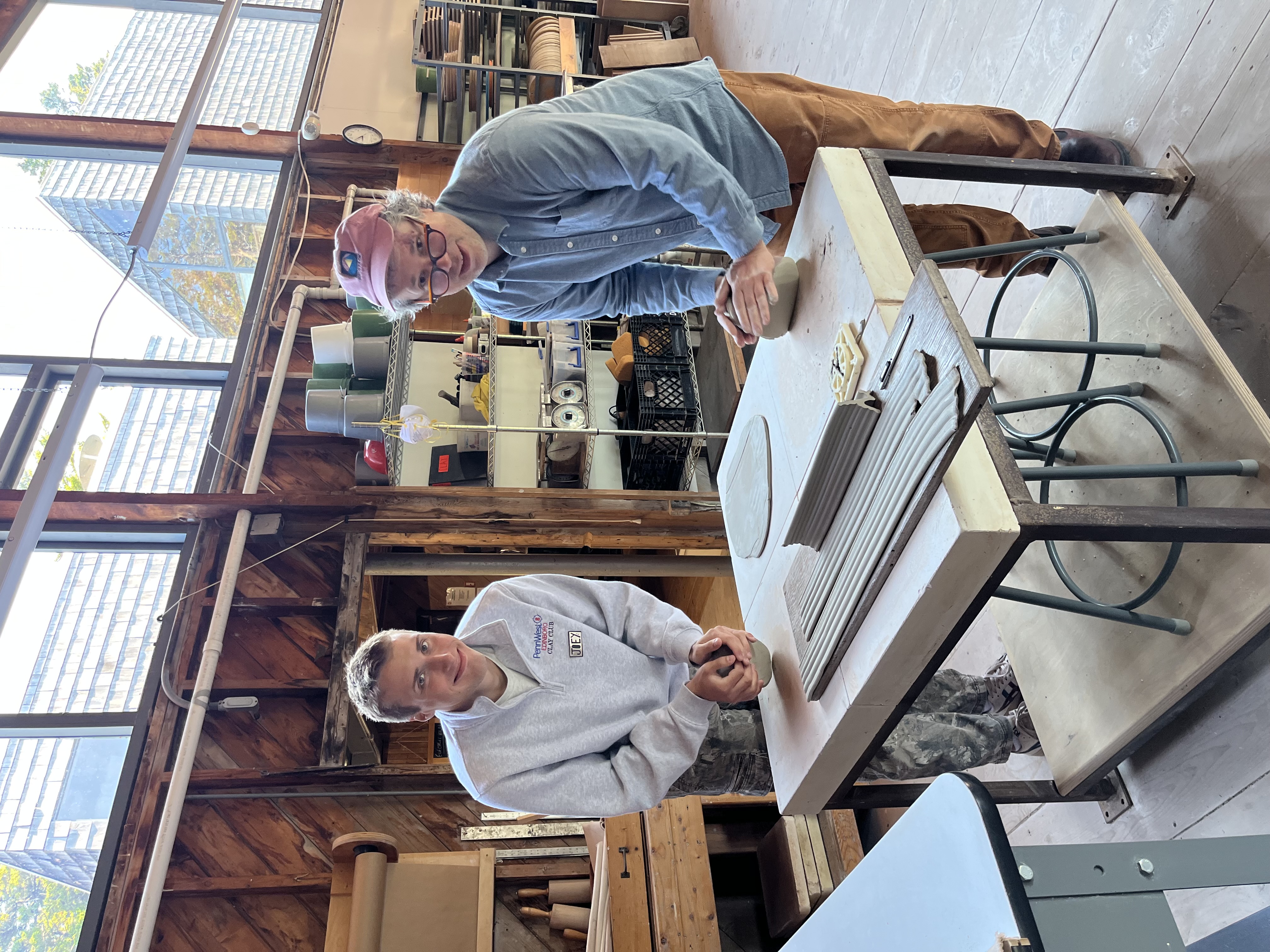 Joey and a fellow ceramicist working with clay in a pottery studio